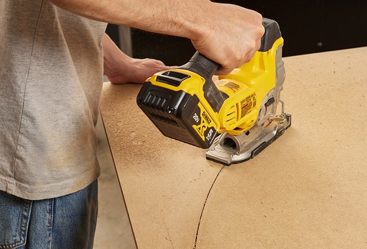 Person cutting an arch shape with a jigsaw