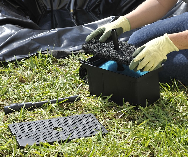 Femme assemblant le filtre d’une pompe à étang