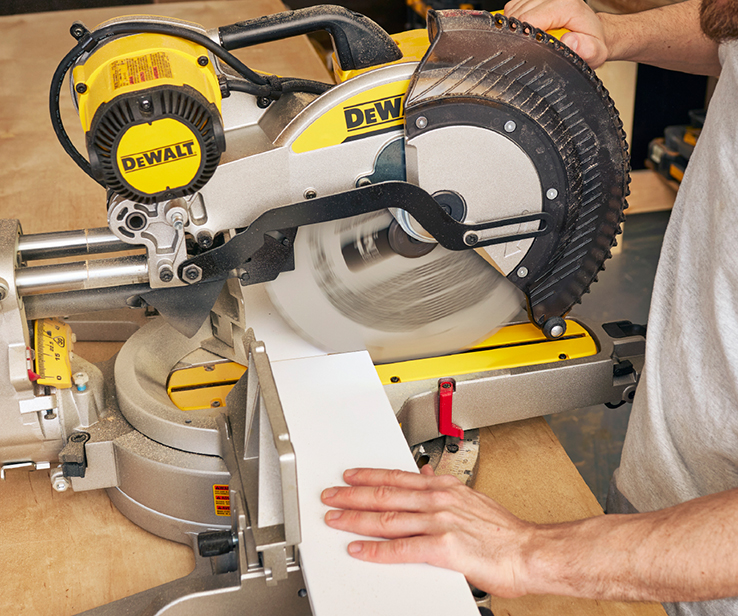 Person cutting mouldings with a mitre saw