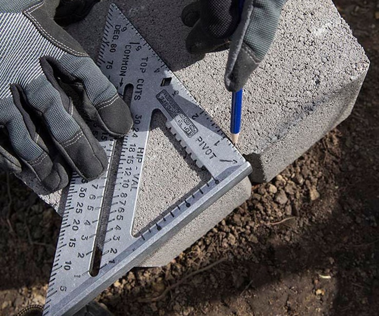 Person tracing a line on a concrete block