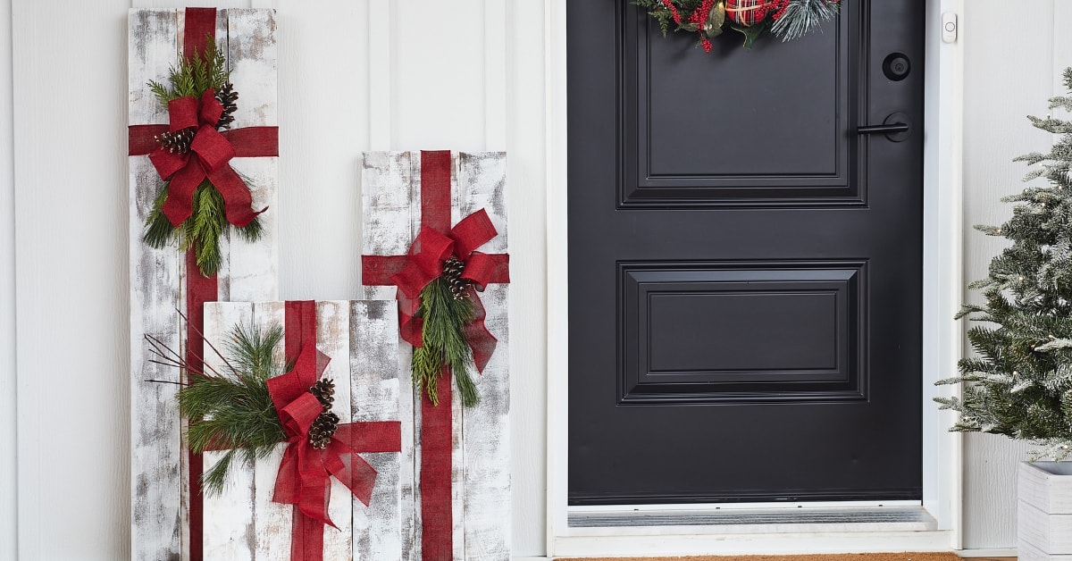 Cadeaux de Noël géants en bois sur un porche