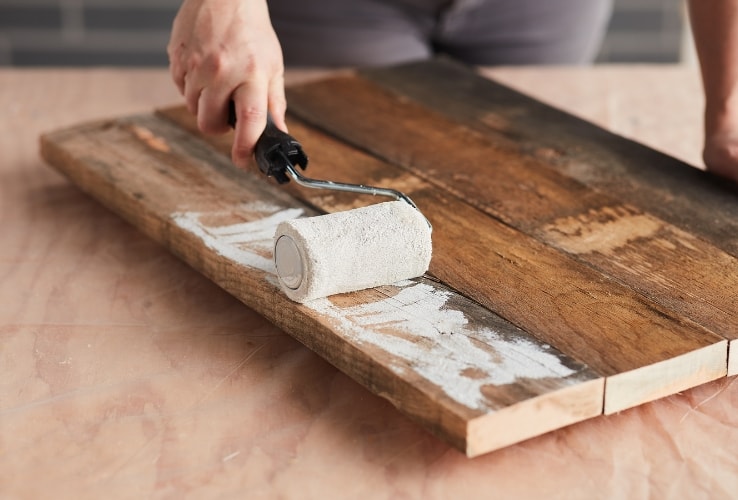 Personne peinturant des planches de bois