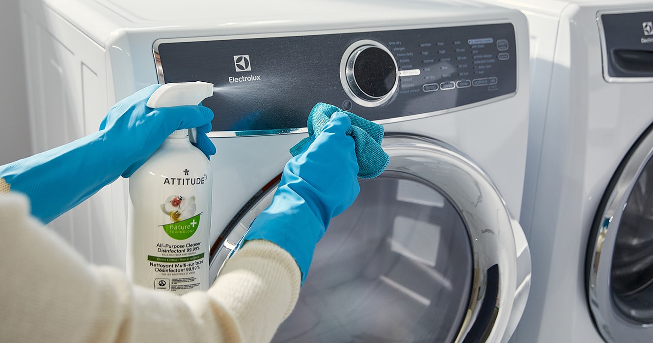 Person cleaning the exterior of a dryer