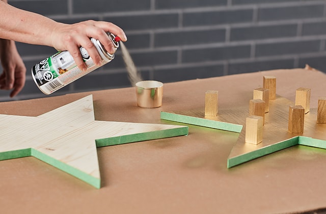 Person spray painting wood gold