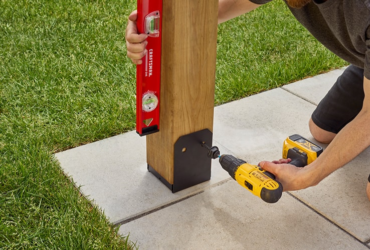 Person securing wooden pergola uprights