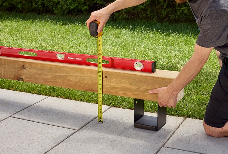 Person checking the level of pergola bases