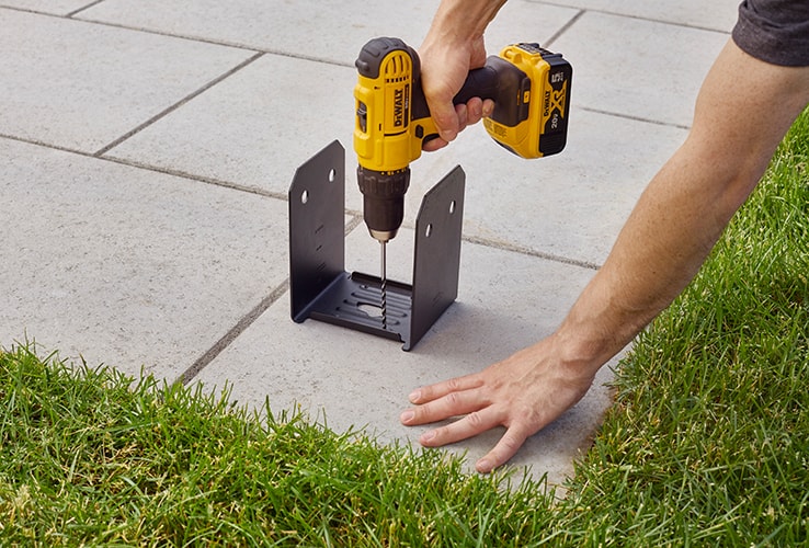 Person installing a metal base on pavers