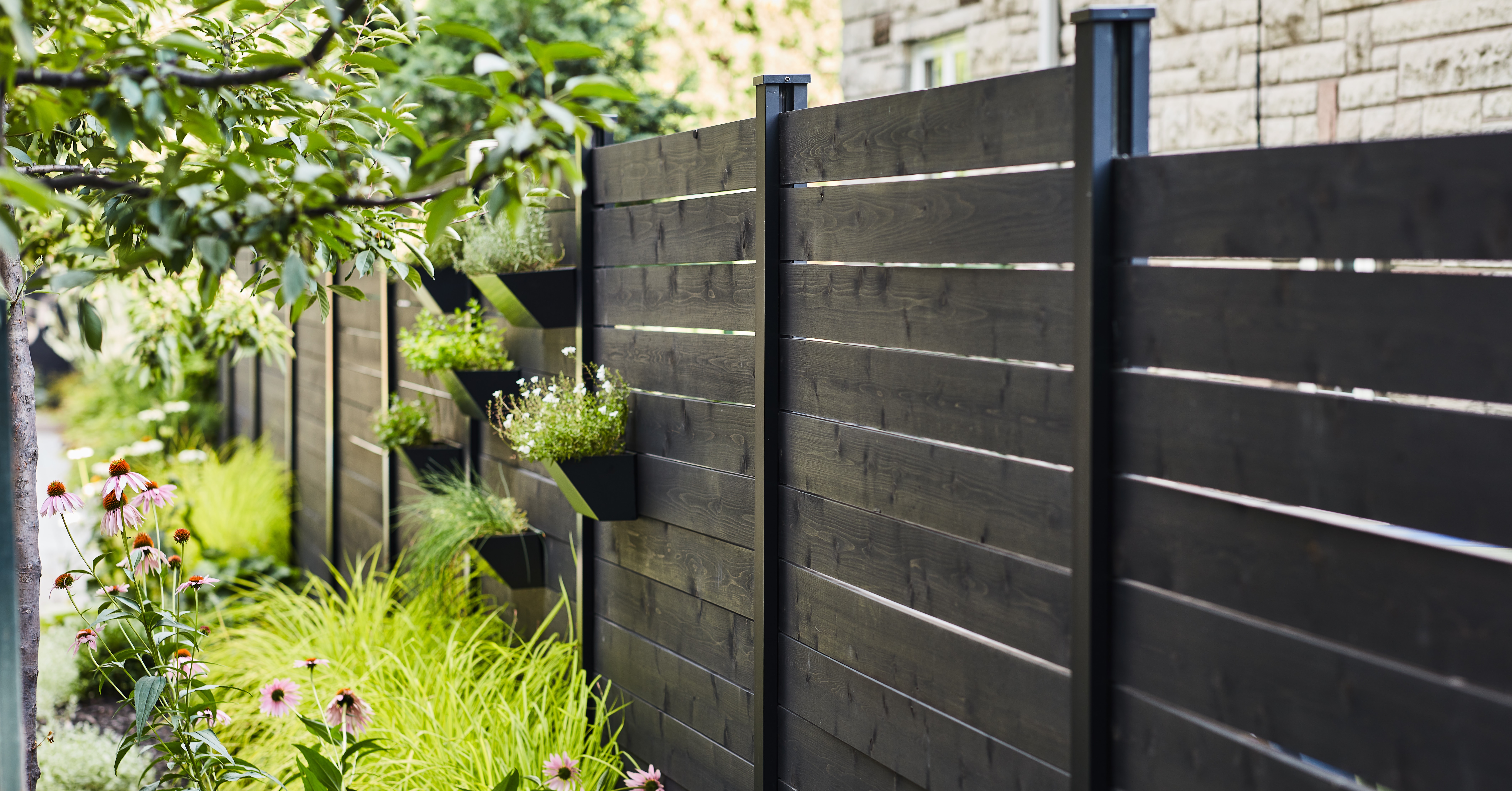 Modern black garden fence with planters 