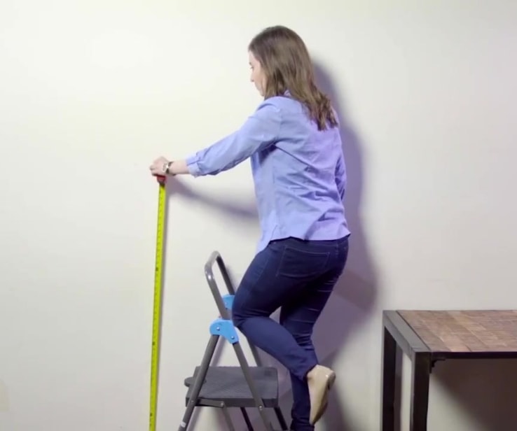 Woman measuring a wall