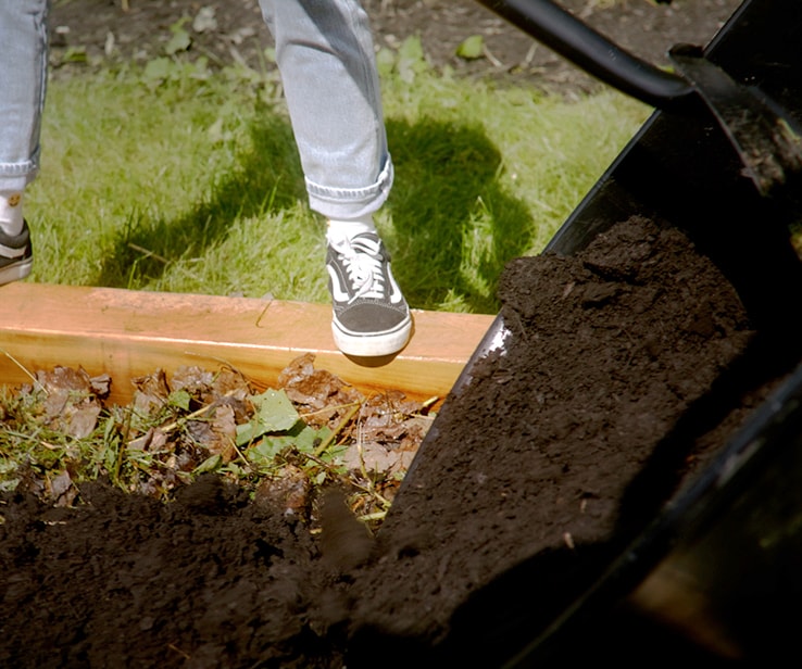 Personne étendant du compost au jardin