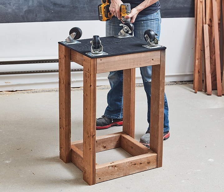 Woman adding casters to a wooden structure