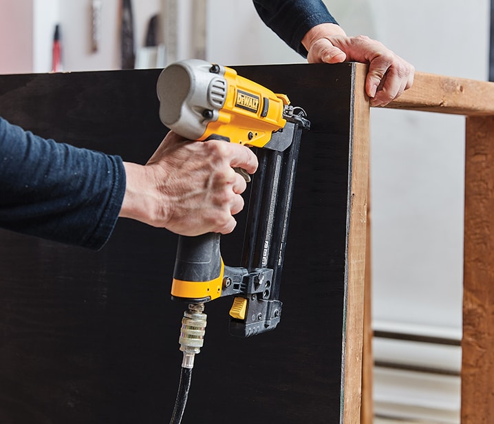 Femme assemblant une structure en bois