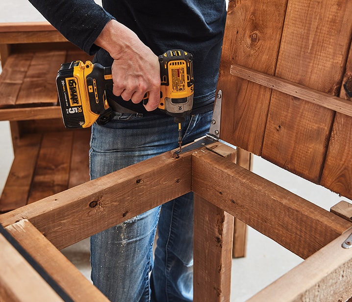 Woman building a wooden outdoor kitchen