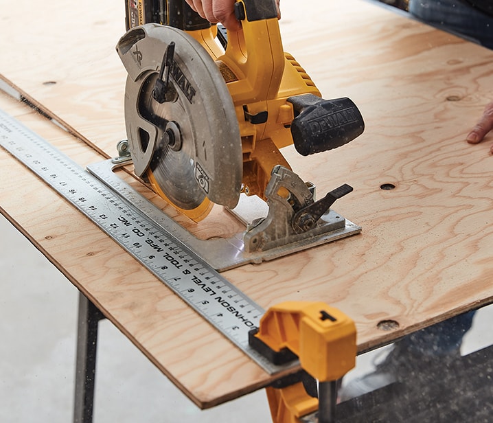 Woman cutting a plywood sheet