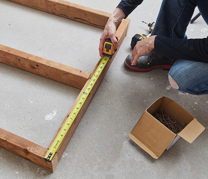 Femme mesurant une structure en bois