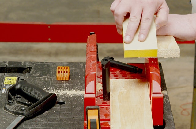 Person sanding a piece of wood