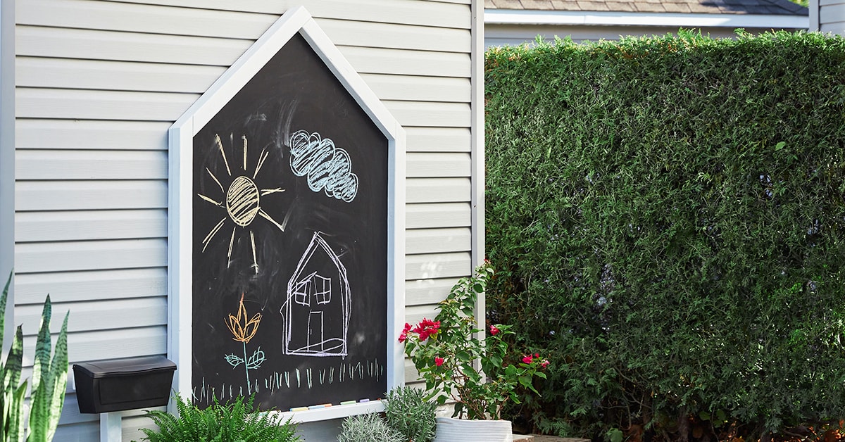 House-shaped chalkboard in a backyard