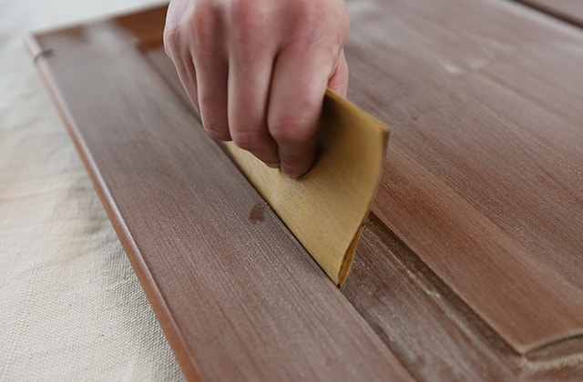 Person using a folded piece of sandpaper