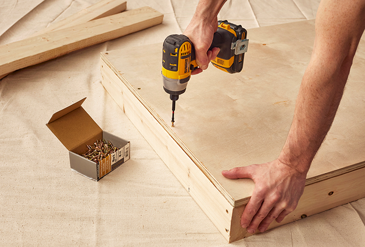 Person assembling a wooden structure