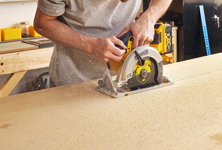 Person cutting wood with a circular saw