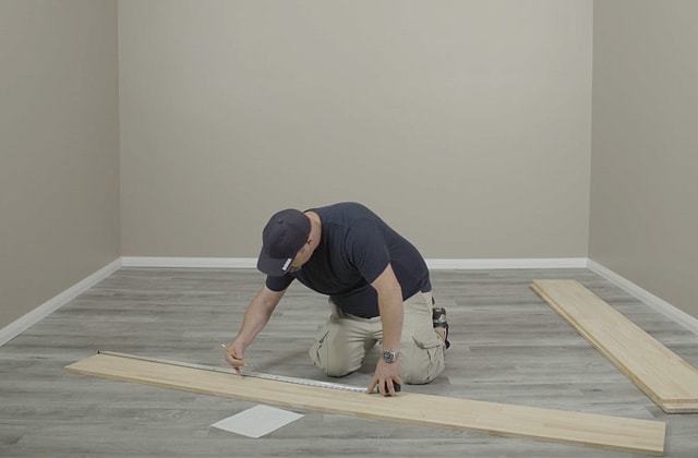 Person measuring a wood plank