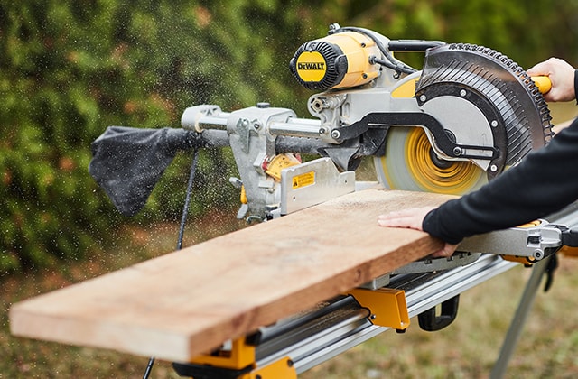 Person using a mitre saw to cut wood