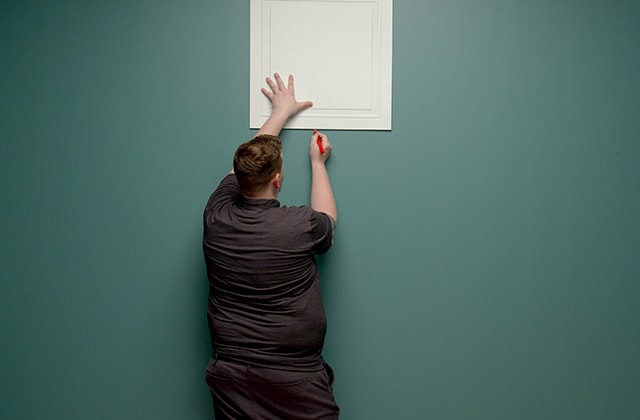 Person making marks on a wall