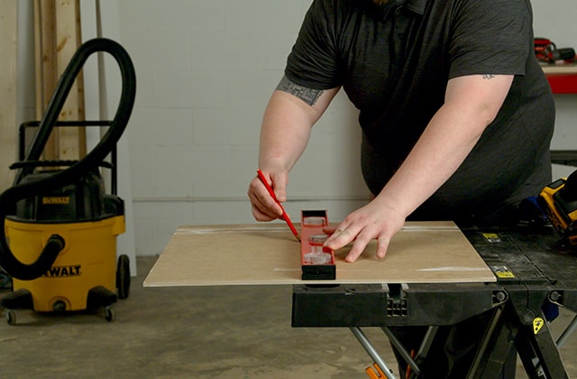 Person transferring a measure onto a tile