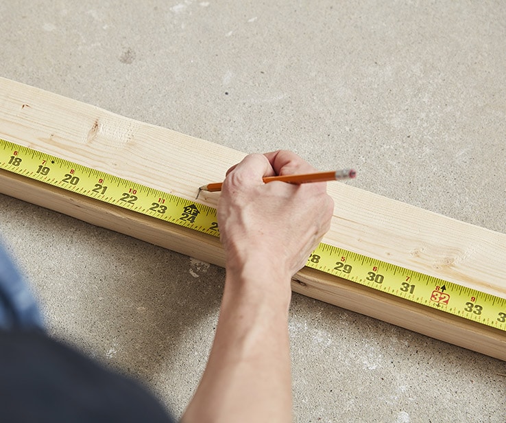 Personne mesurant une planche de bois