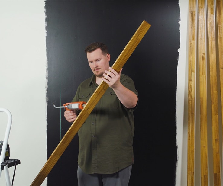 Man applying adhesive onto wood slats