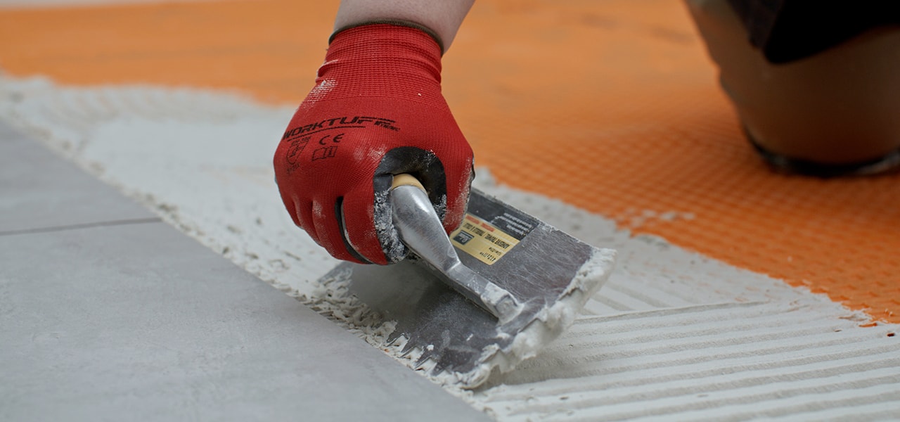 Homme posant un plancher de céramique