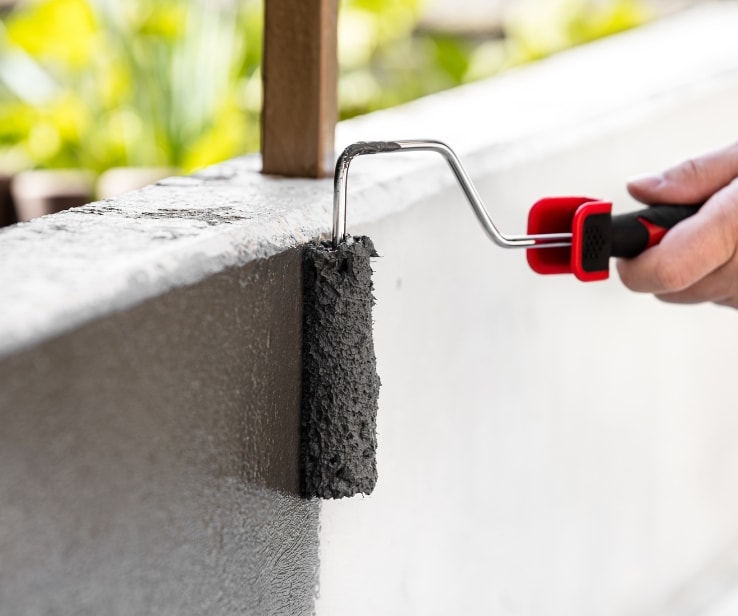 Personne peinturant une surface en béton