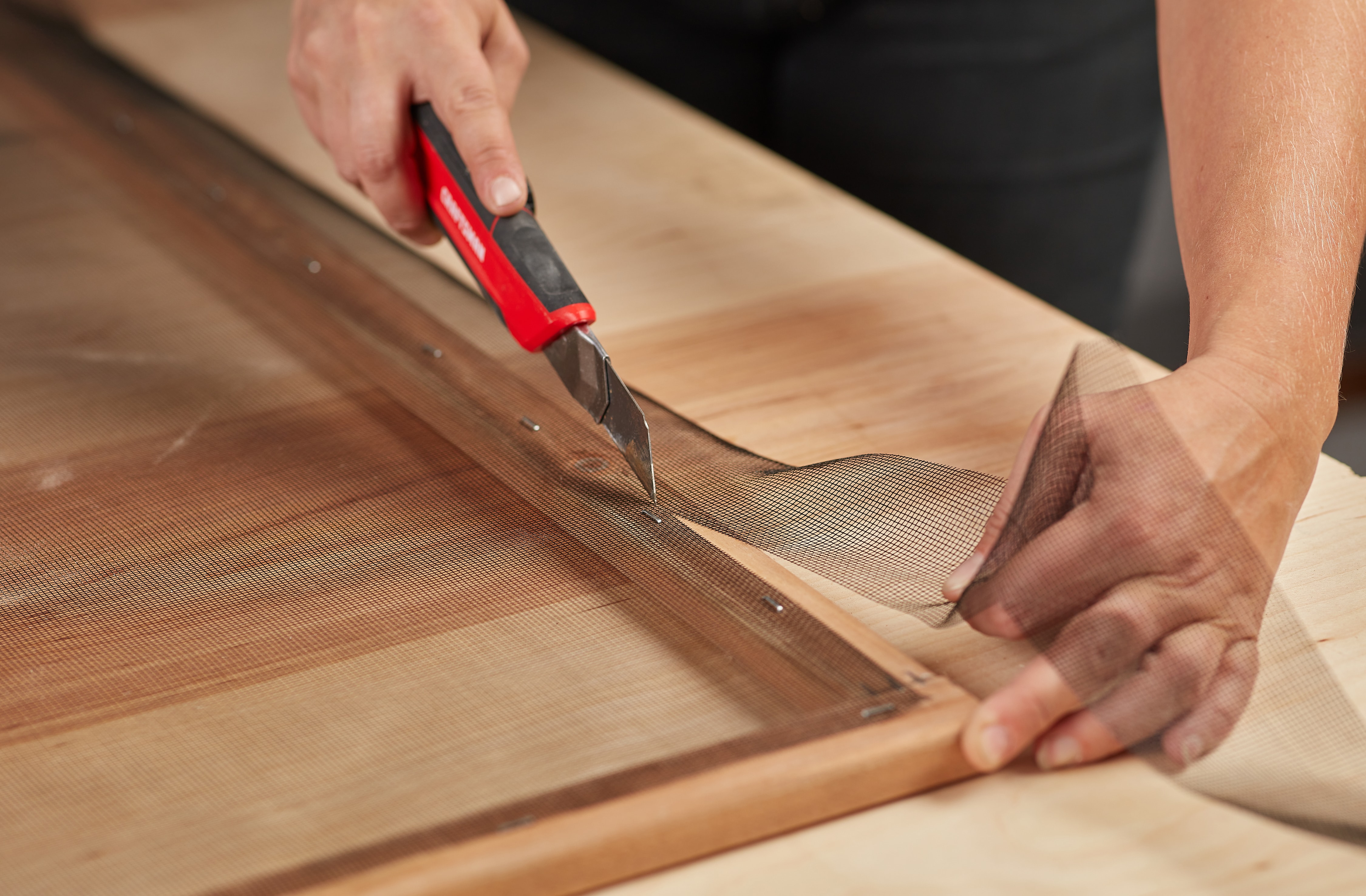 Person using an all-purpose knife to cut mesh