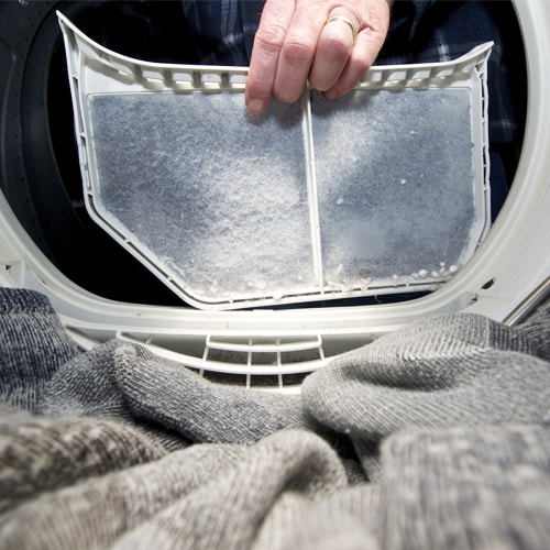 Person cleaning a dryer lint filter