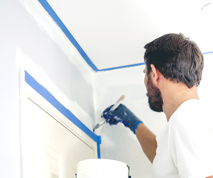 Man trimming mouldings with paint