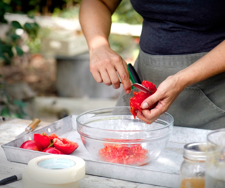 Woman removing tomato seeds with a spoon